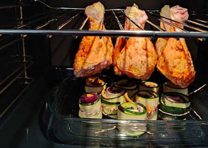 Hähnchenkeule am Galgen mit bunten Gemüserollen